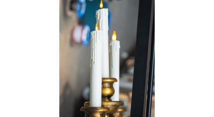 A candelabra with three candles, a stage prop with artificial lit flames.