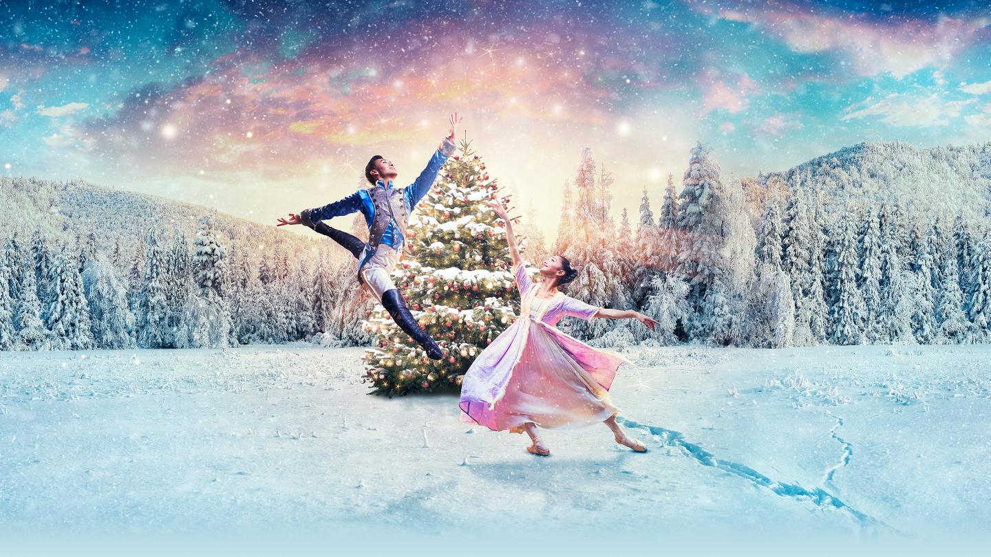 Clara and the Nutcracker Prince dancing in the snow in front of a Christmas tree