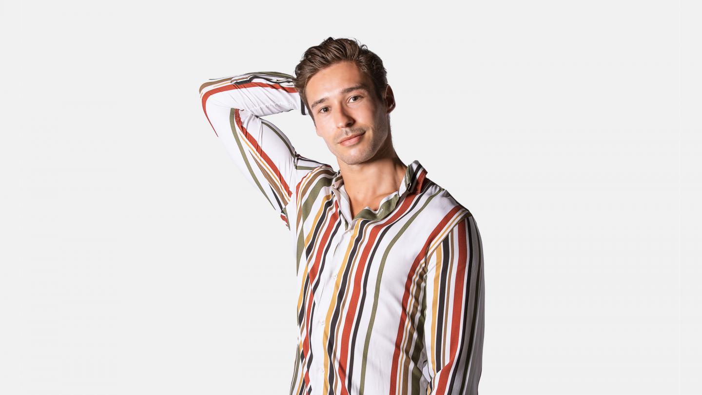 A headshot of a male dancer in a red striped shirt