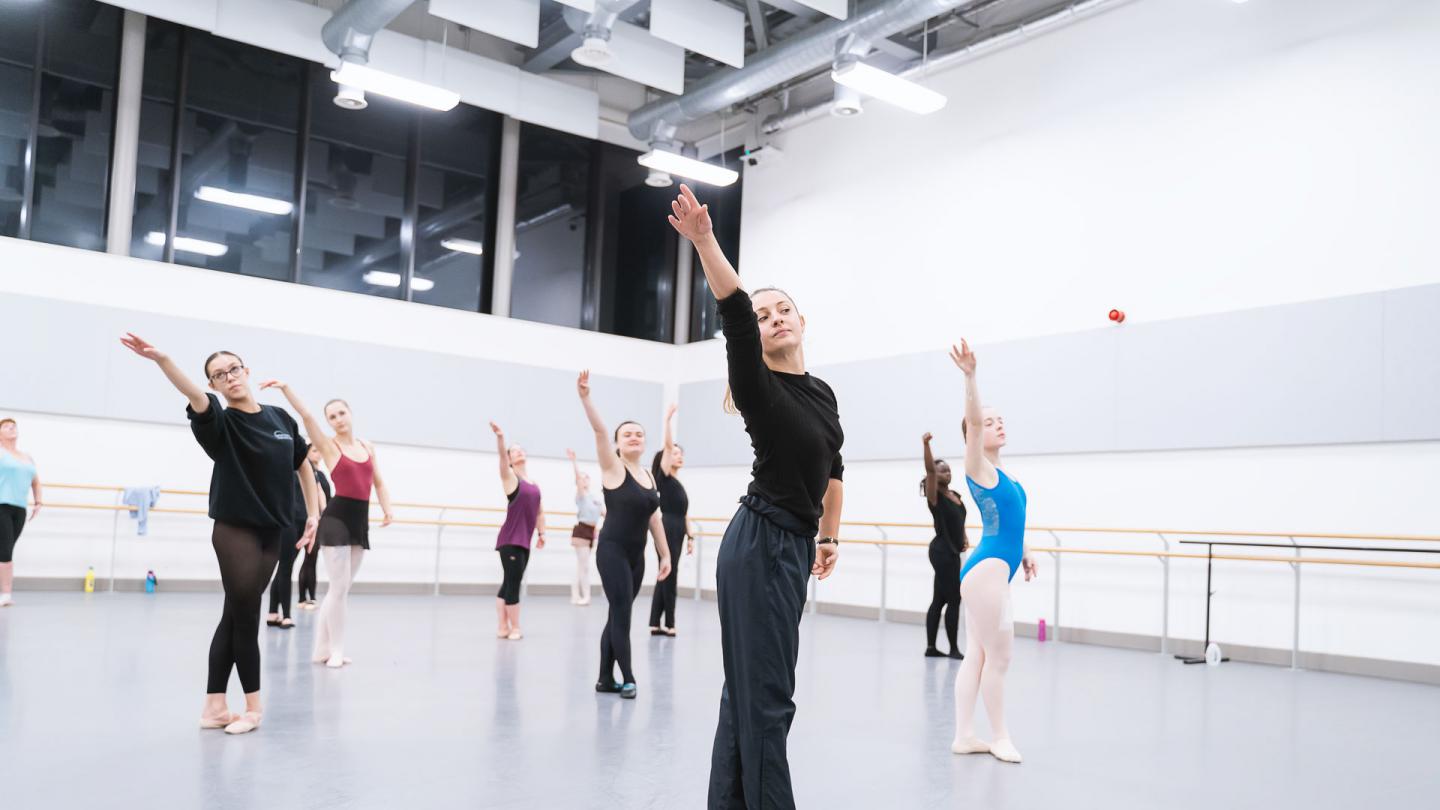 Around 10 people participating in a ballet class