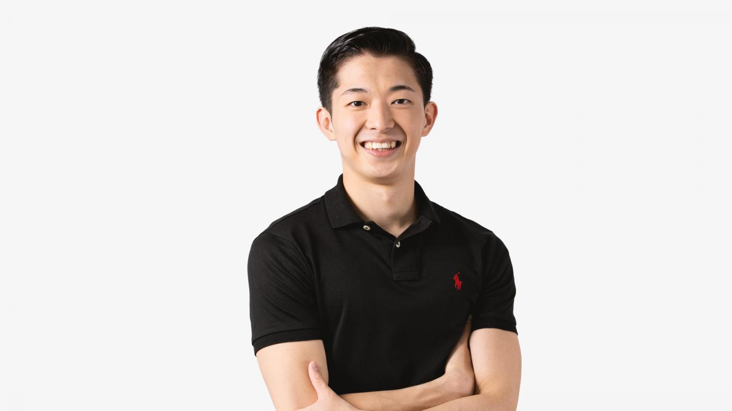 A headshot of a man looking forward in a black polo shirt