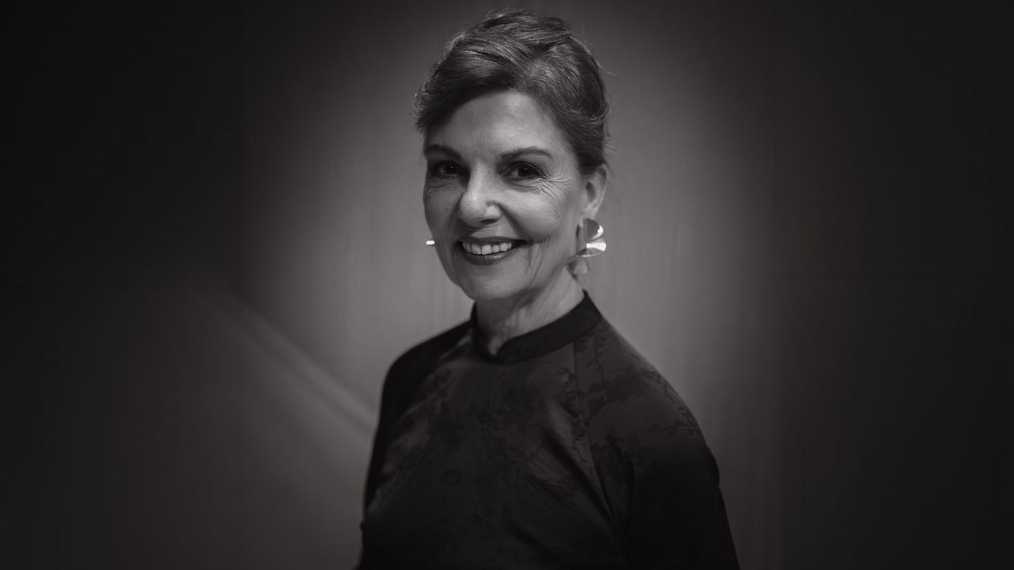 Black and white photo of woman smiling broadly at the camera.