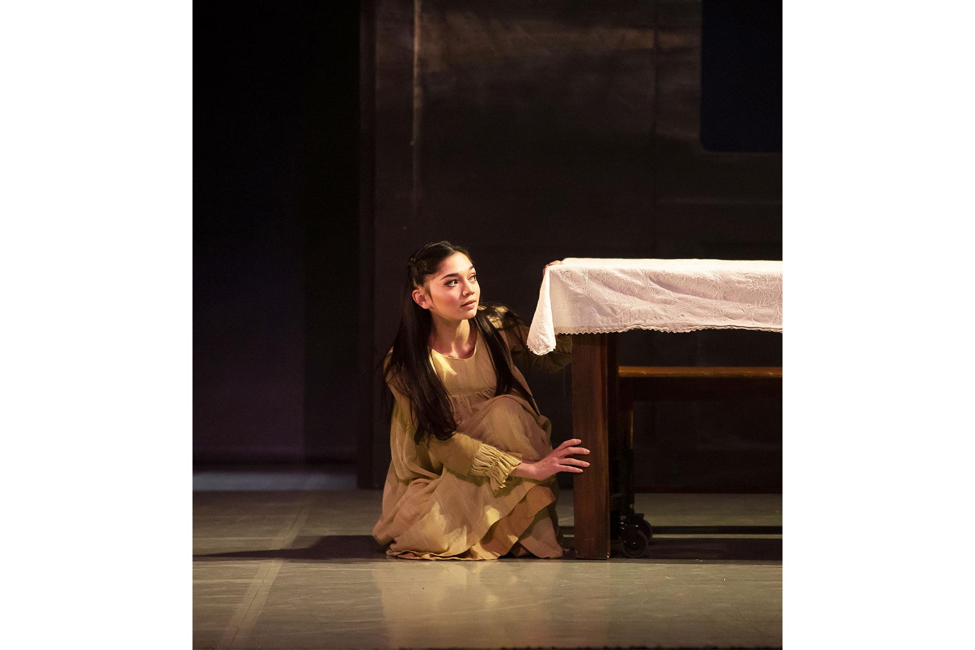 Playing in the kitchen, young Cathy hides behind the table