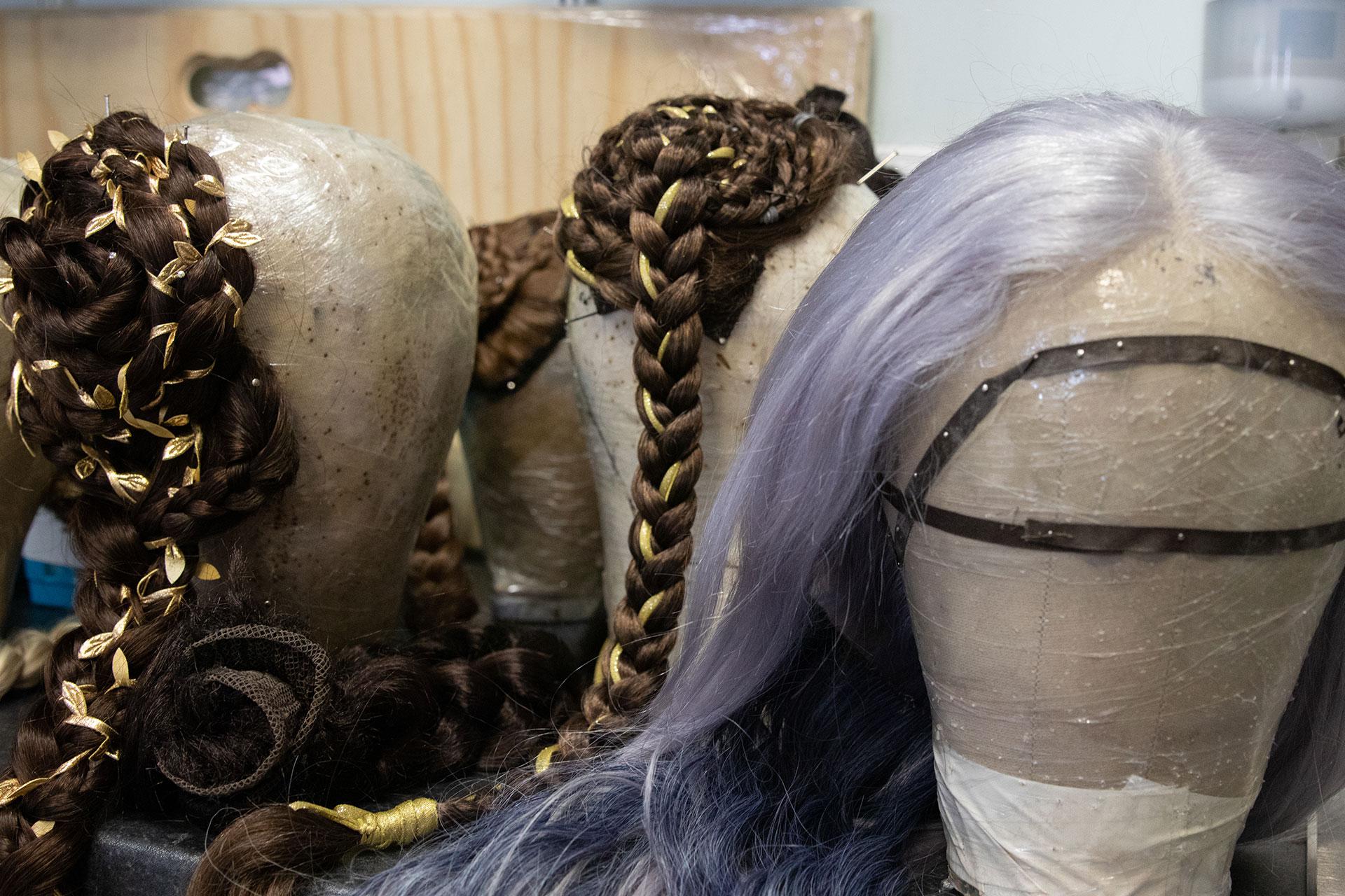 Three wigs and hair extension from Merlin on display on mannequin heads in Wardrobe