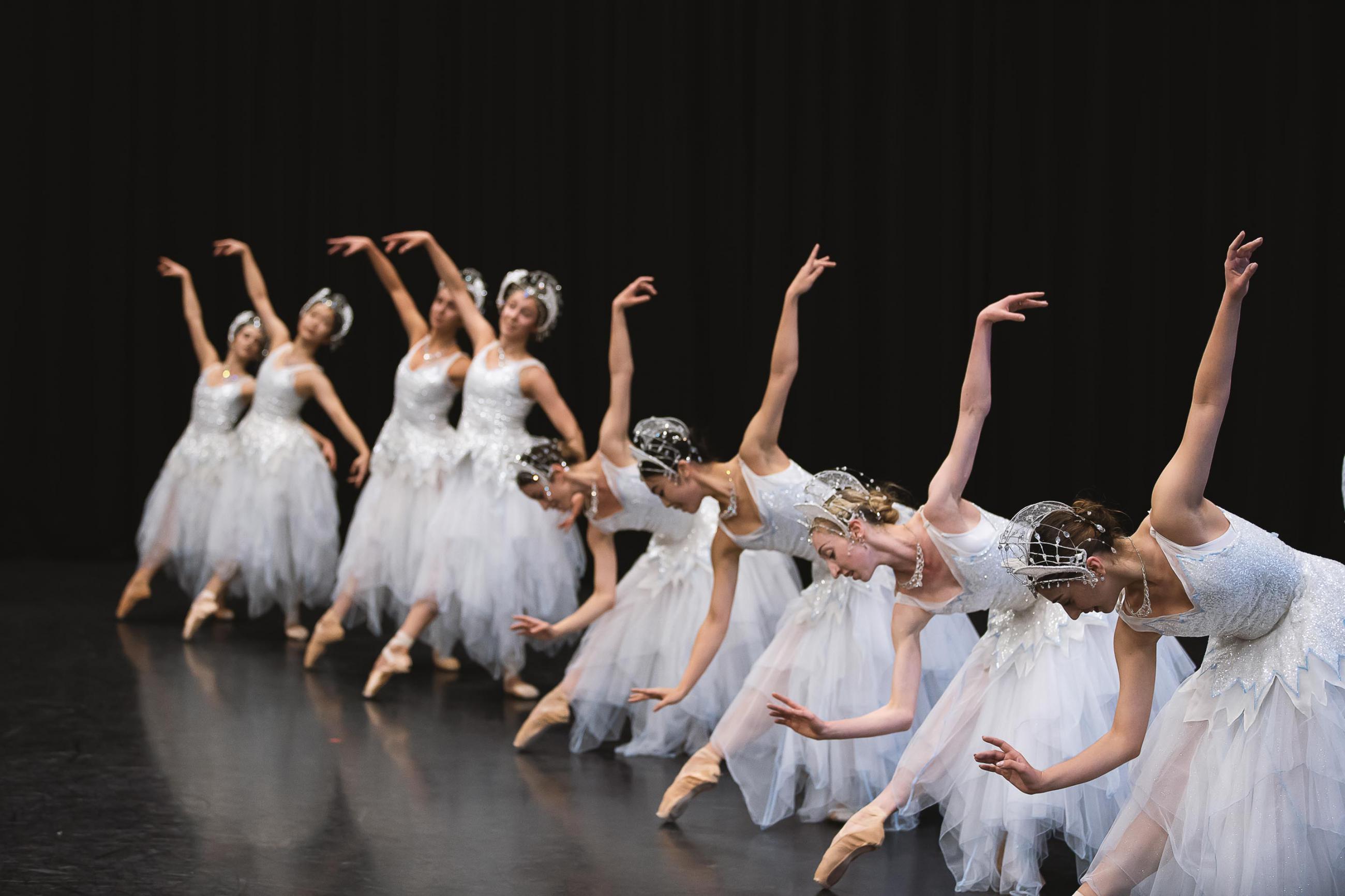 Dancers all in a line bowed forward