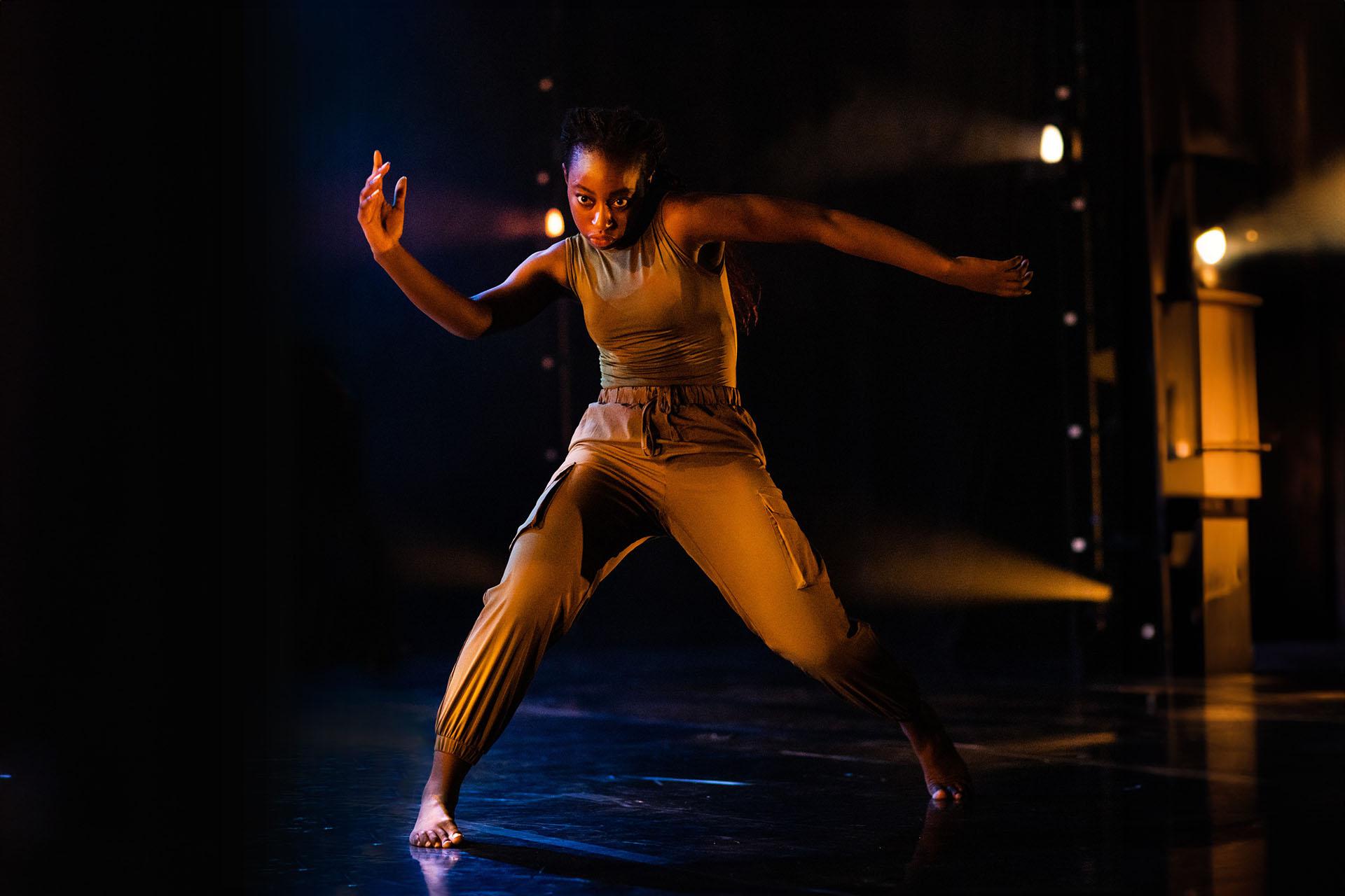 Phoenix Youth Academy senior looking directly at the camera, standing with legs apart, weight on the right foot, shoulders high and arms raised