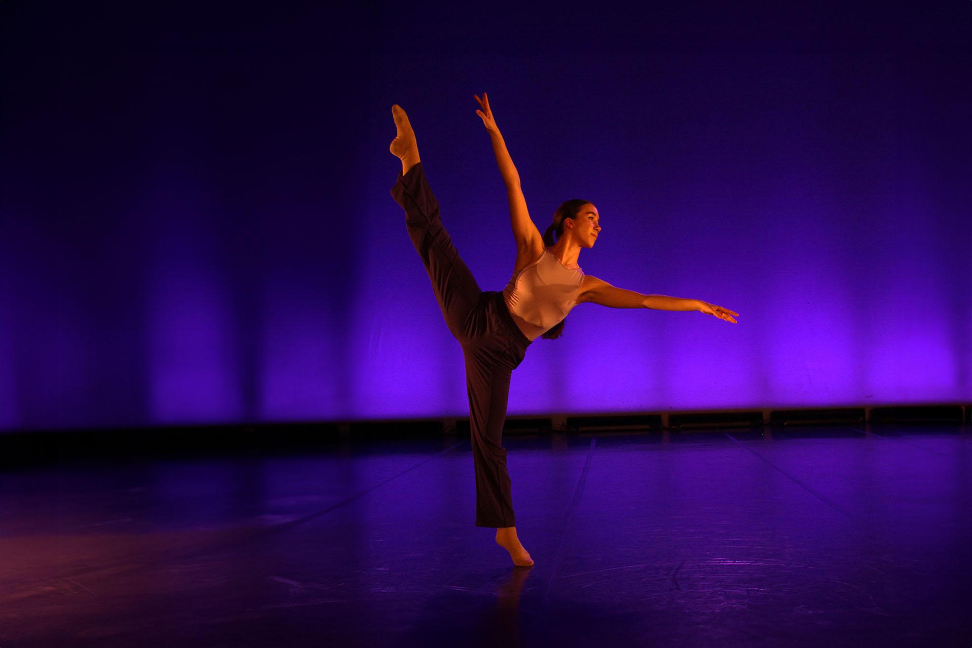 A phoenix Youth Academy Senior soloist on her toes of one foot, the other leg raised straight and high, one arm upright parallel with her leg the other stretched out for balance