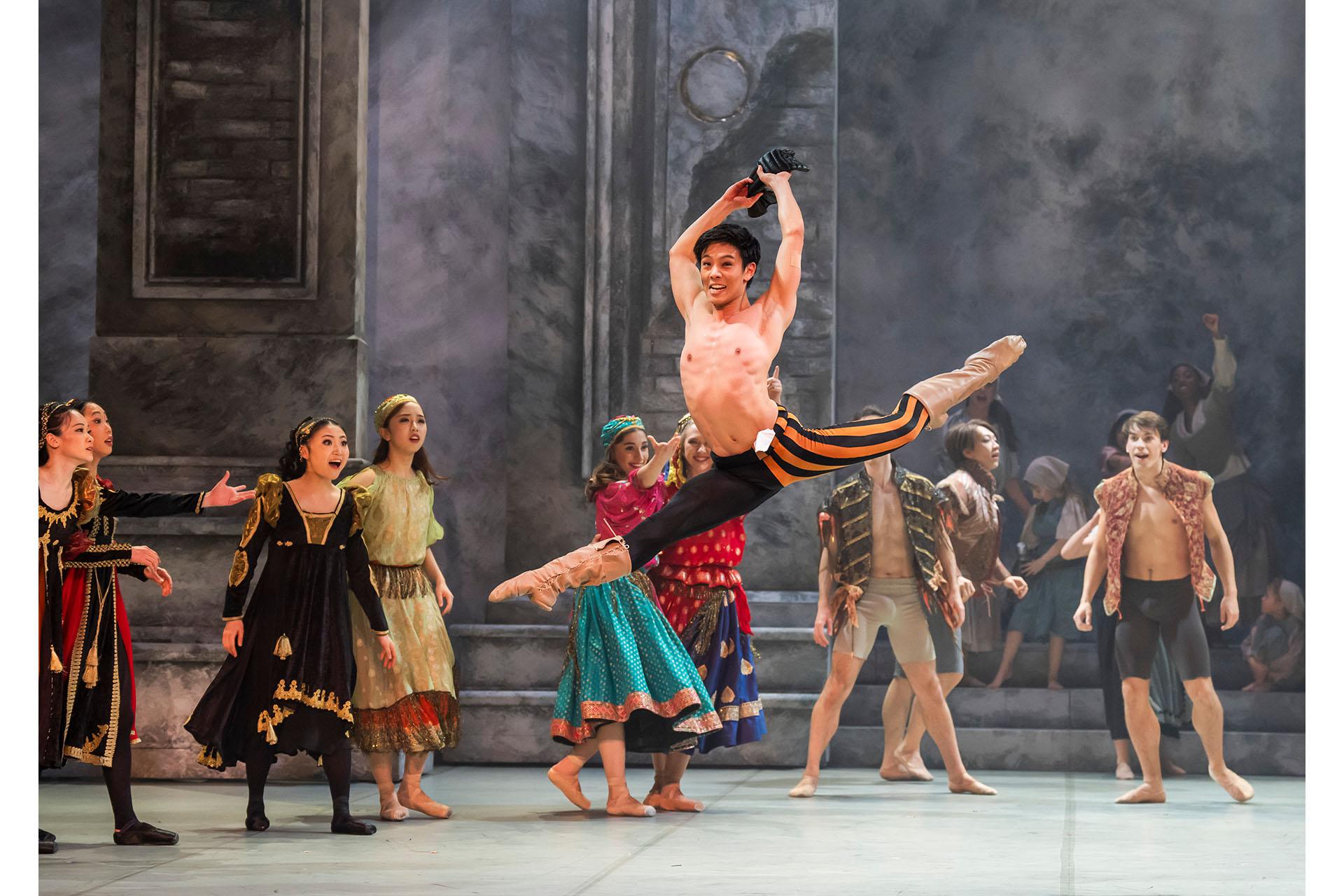 A male dancer jumping in splits