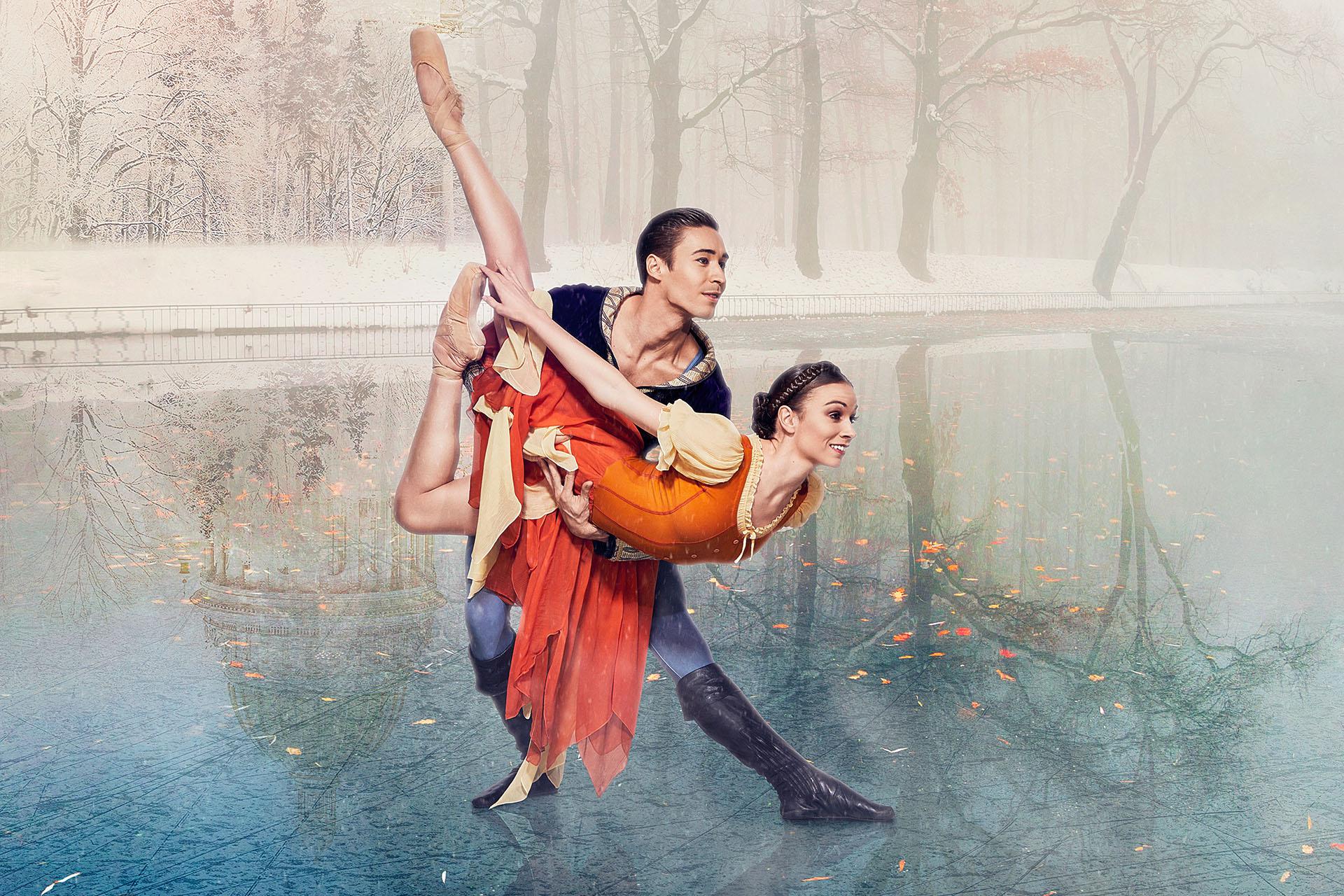 Dancer in an orange dress leans forward her legs raise behind her, she is held by a man in blue with black leather boots