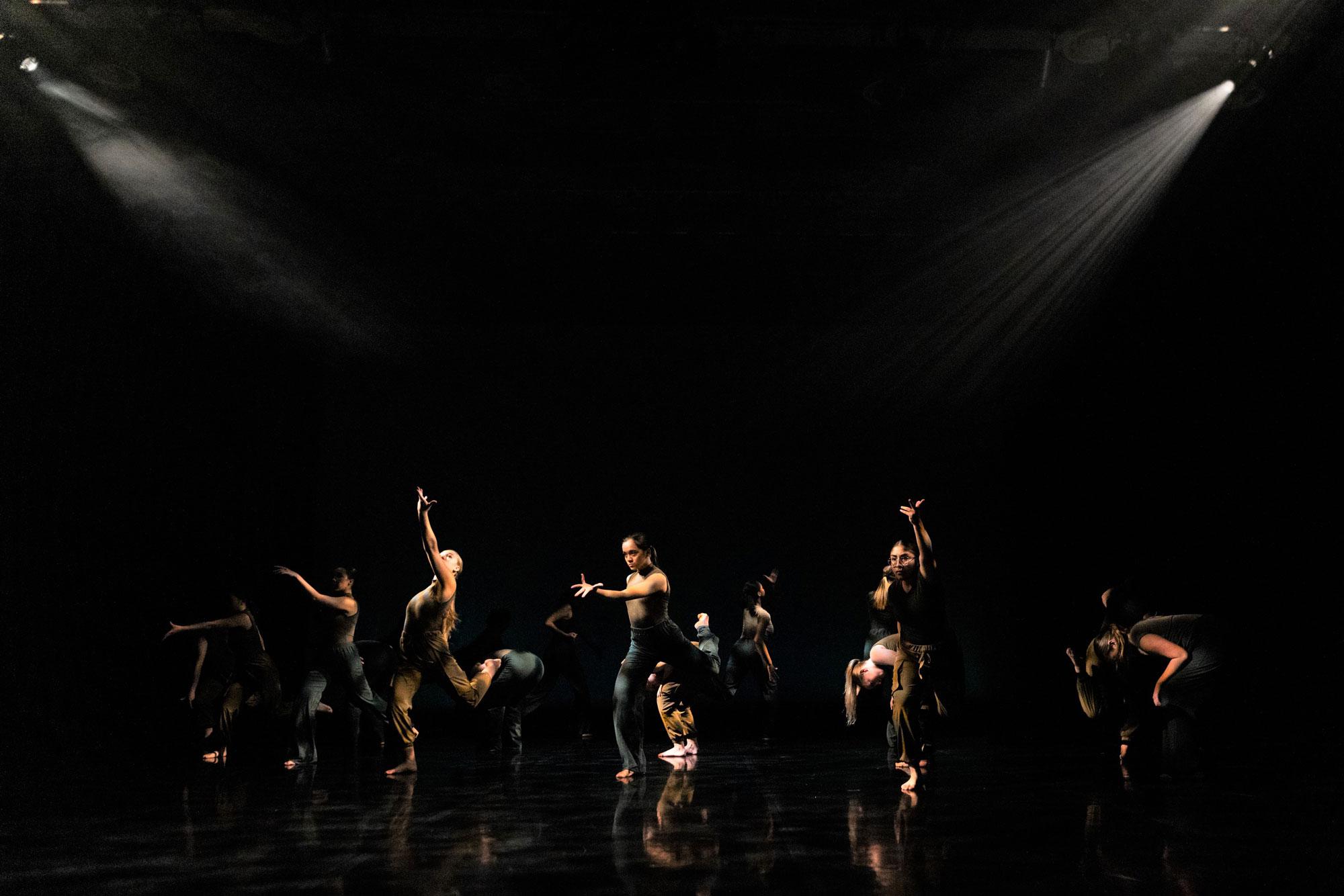 Phoenix Youth Academy, Photo Finn Johnson A photo of a group of dancers in various dance positions against a black background with atmospheric white light