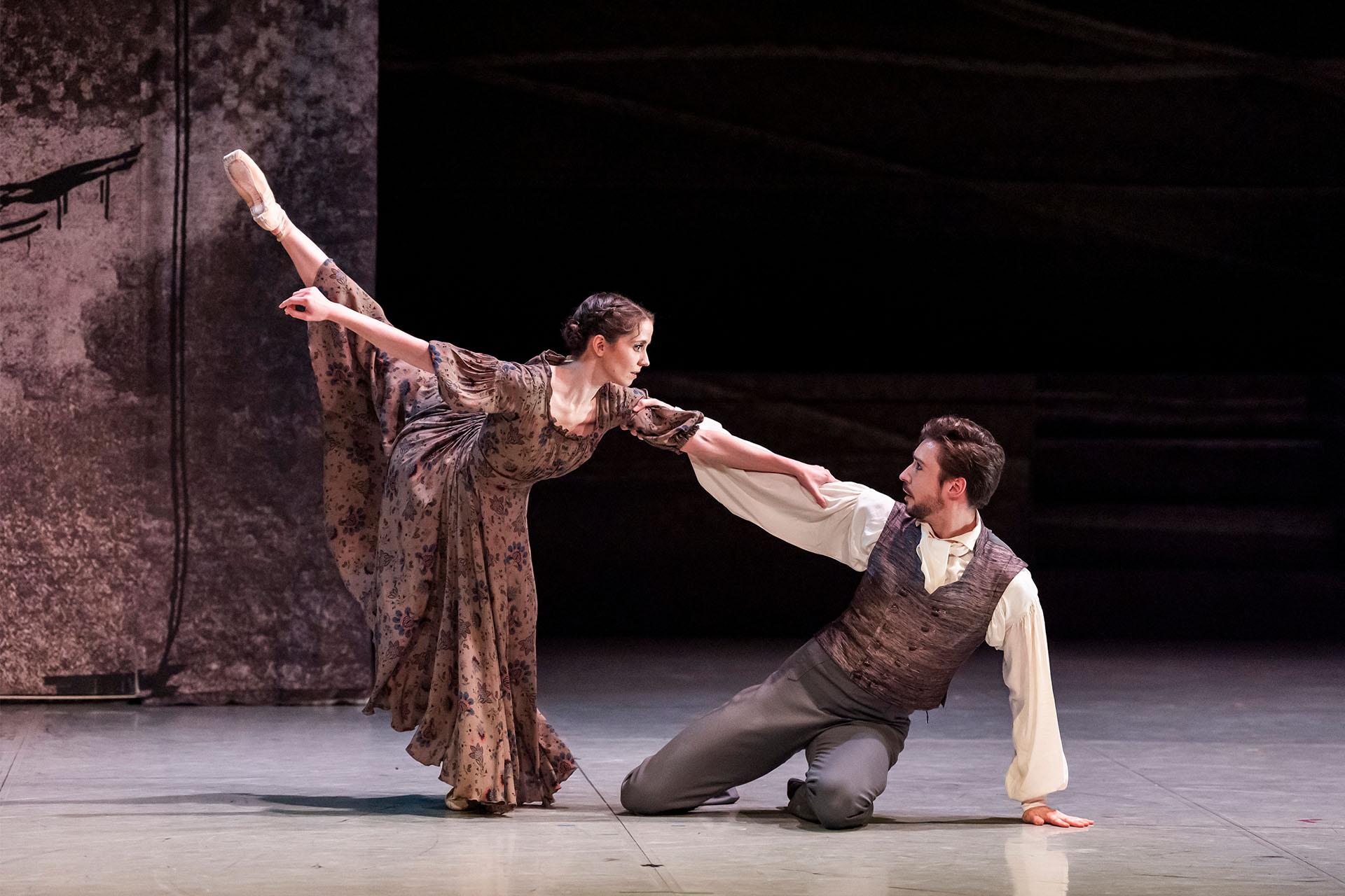 Jane and My Rochester hold on to each other, him on the floor reaching up to her, and Jane holding his arm, her leg arabesque away from him