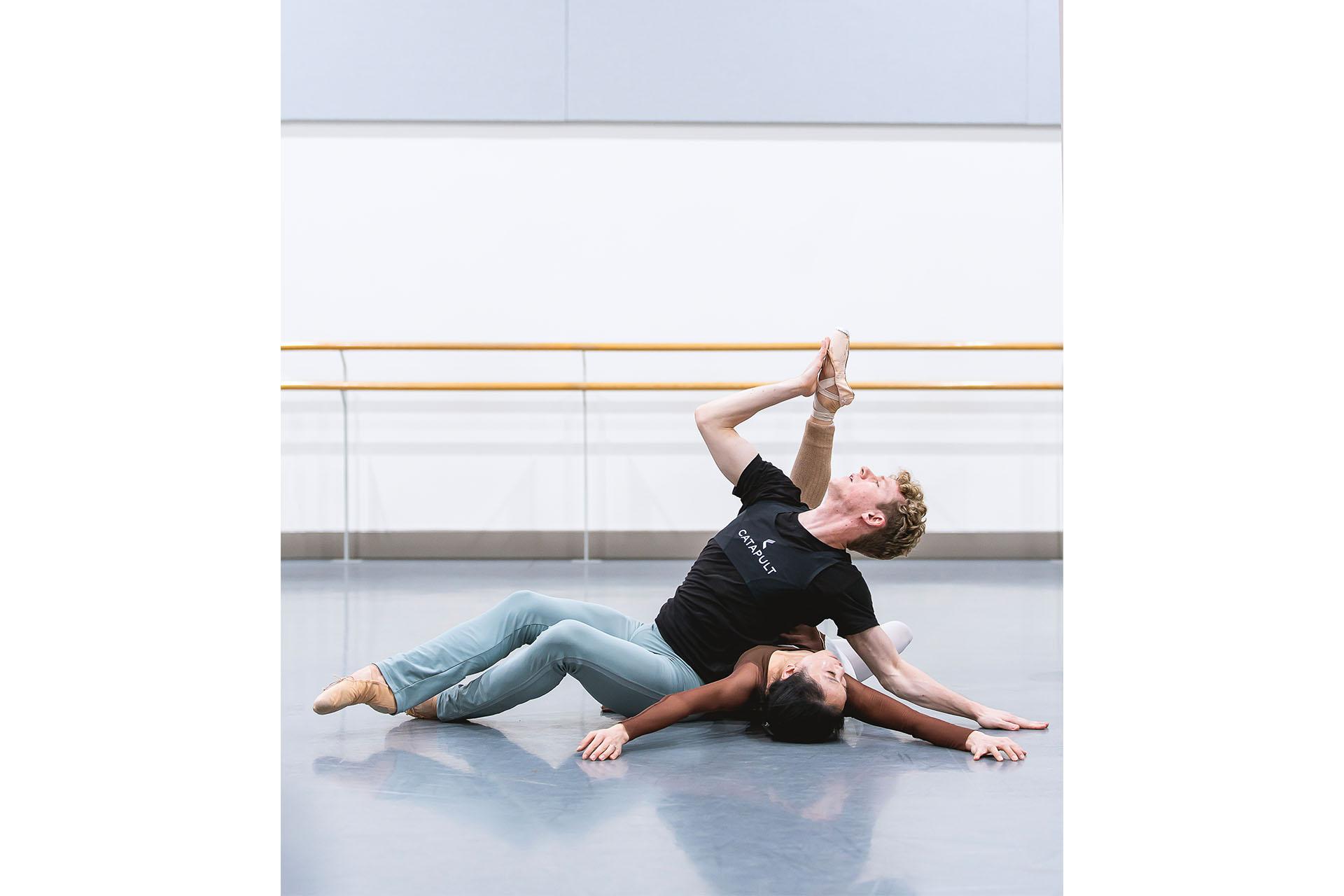 She lies back on the studio floor, her arms outstretched and he legs lifted by him as he relaxes against her