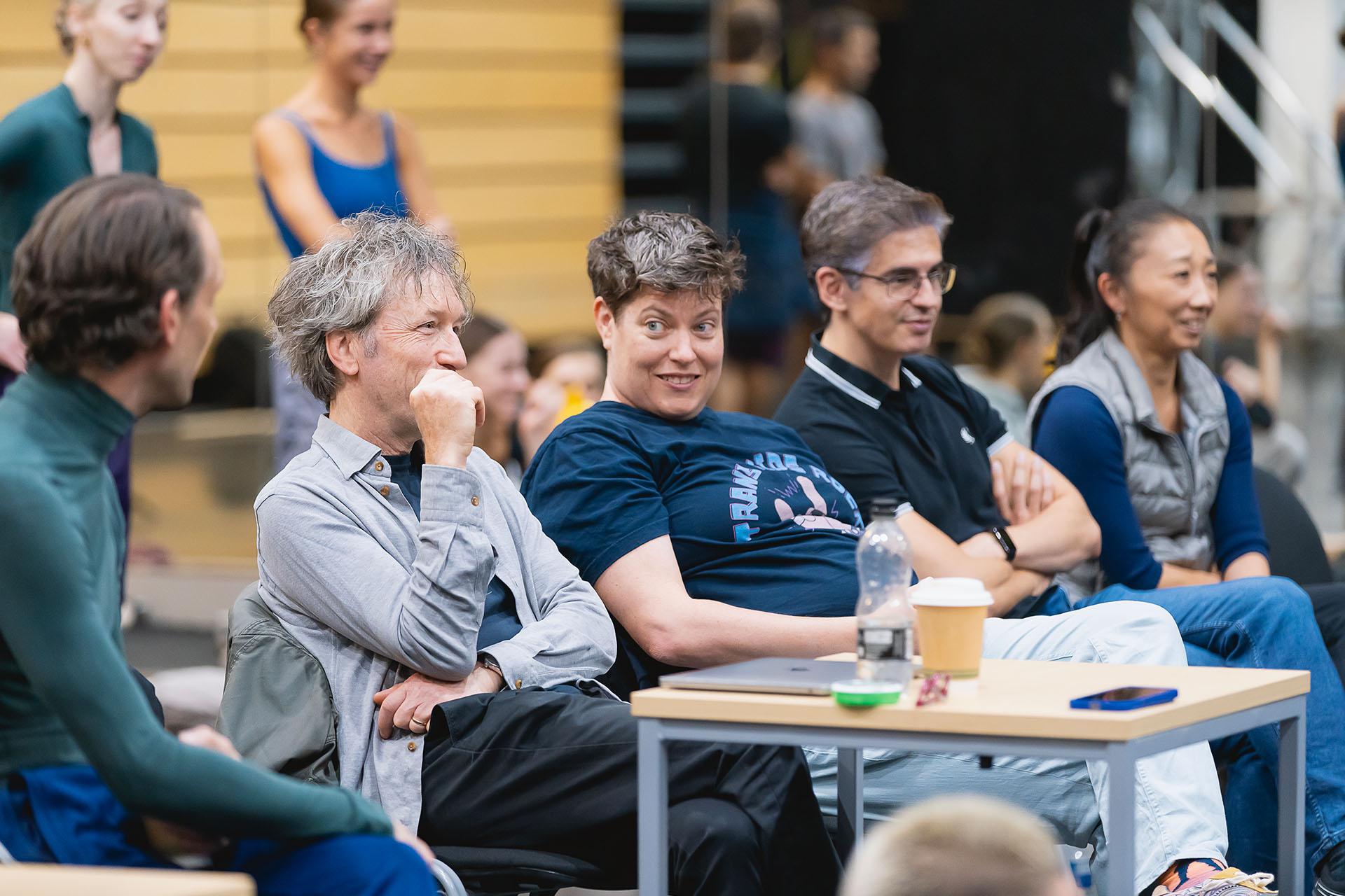 Creatives in discussion while they are sat in the studio watching the creation process