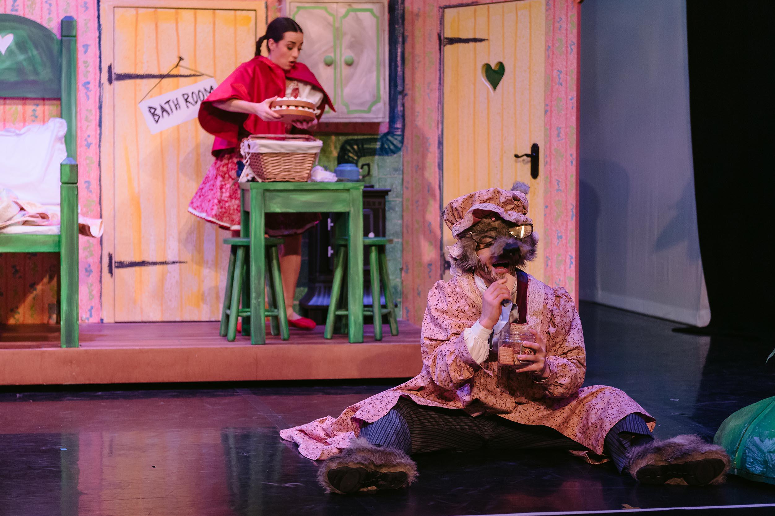 A dancer dressed as a wolf is pretending to eat