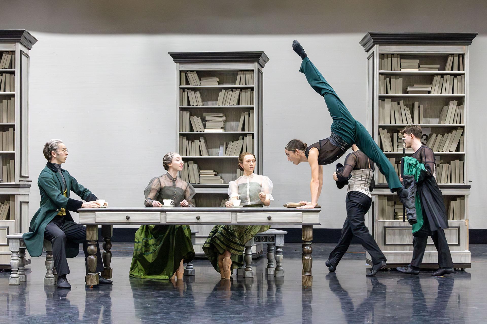 Around the dining table three sit and look on at Anne Lister whose lifting herself off the ground in anger