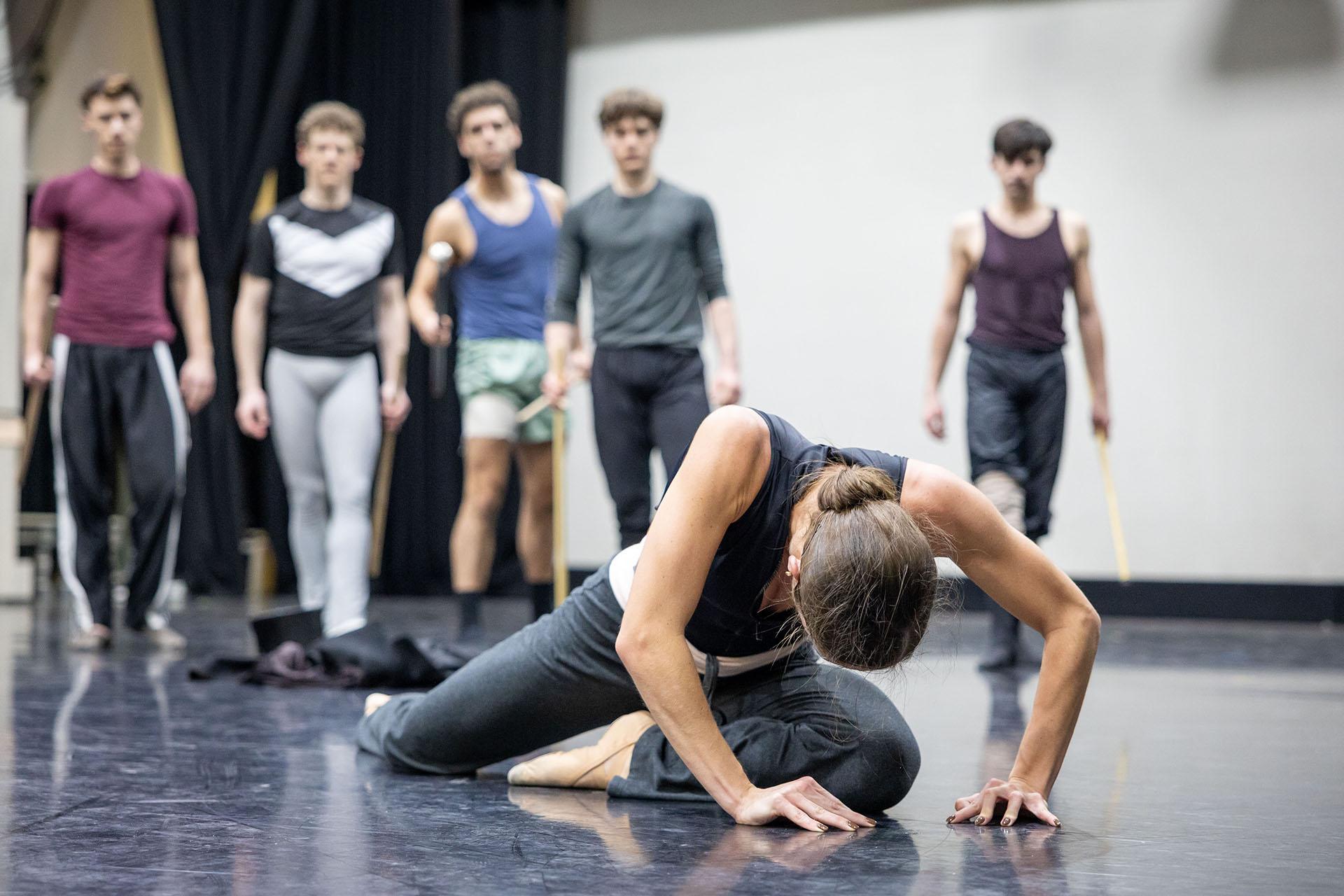 A dancer rehearing a character on her knees, hands on the floor and head down, dejected