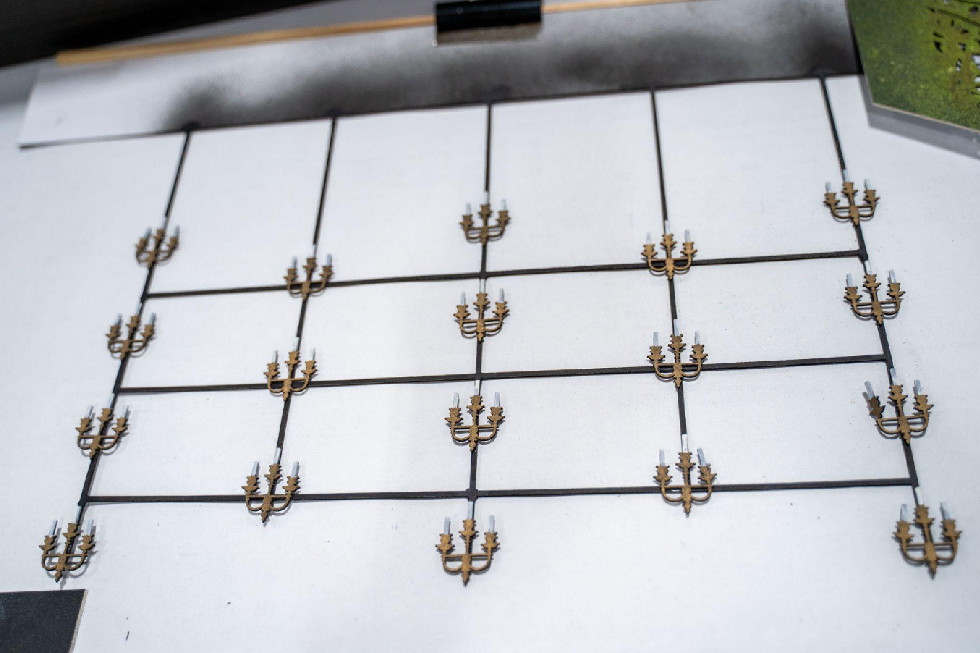 A model of a series of 18 candelabras on a white background.