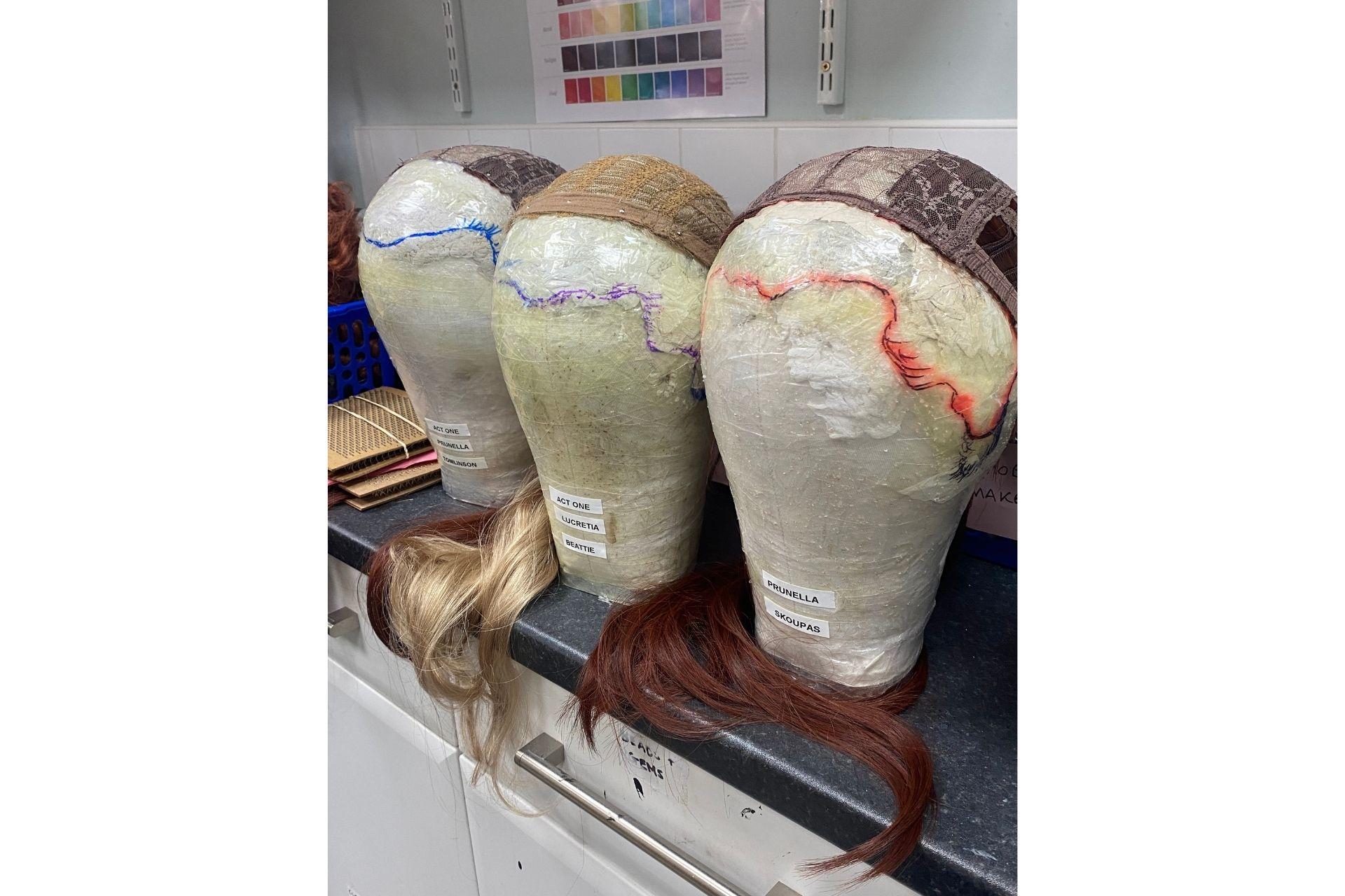 Three mannequin heads with outlines of where a wig's hairline will be