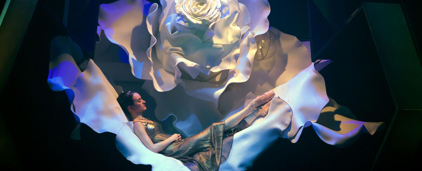 Dreda Blow as Beauty sleeping in a giant white rose. Photo Emma Kauldhar.