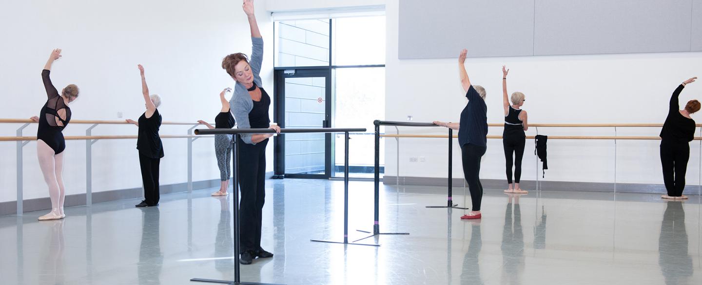 Dancers over 55 practicing at the barre