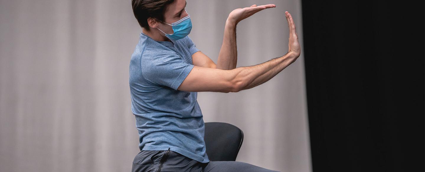 Dancer holding his arms in a stylised pose