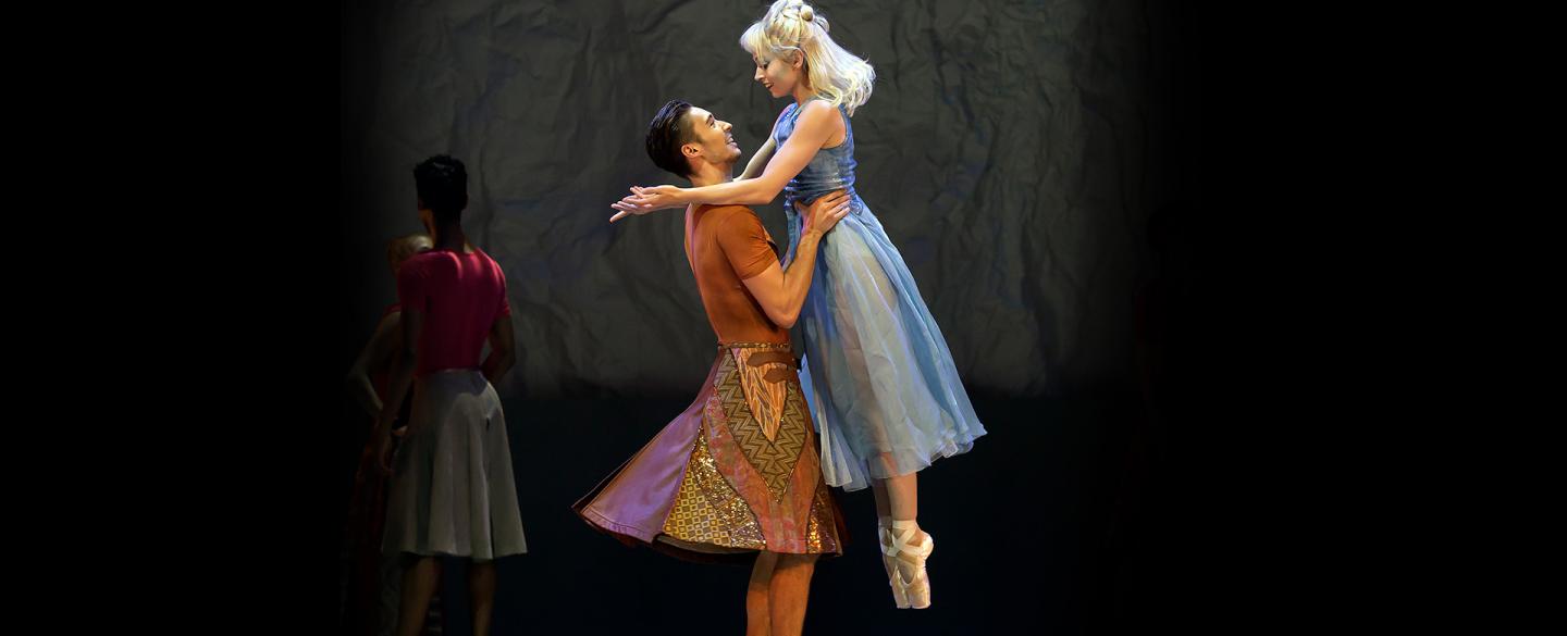 Dancers look into each others eyes lovingly as one gently lifts the other