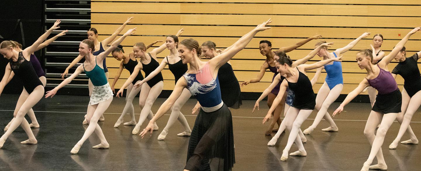 Charlotte Tonkinson in a ballet pose with academy students
