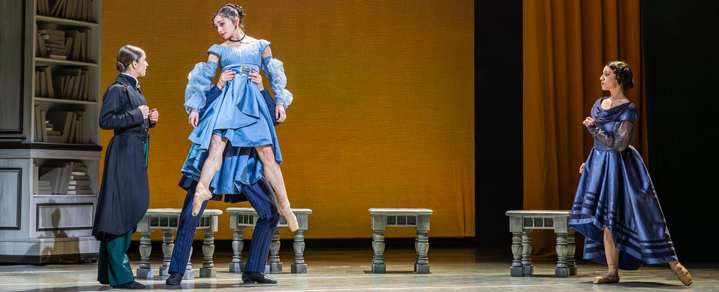Anne Lister in a frock coat looks at Marianne, wearing a blue dress and lifted from the waist by her father as her mother looks on