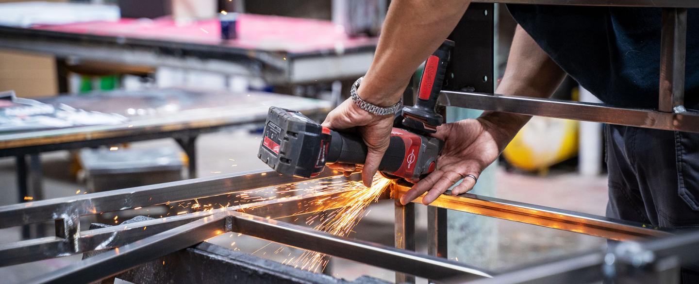 Detailed photo of work on a metal structure with sparks flying from a grinding tool