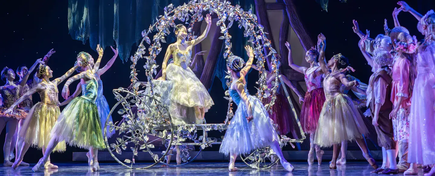 Cinderella waves from her crystal carriage at the crown of beautiful guests