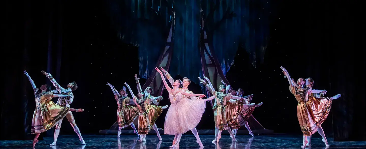 The group all in unison dancing at the final ball, in front the Prince and Cinderella