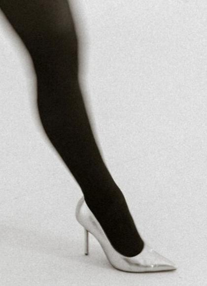 Legs wearing black tights and silver stilettos striding purposefully