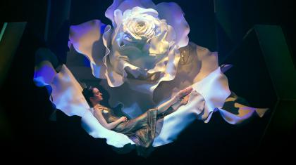 Dreda Blow as Beauty sleeping in a giant white rose. Photo Emma Kauldhar.