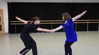 Two people dance in a studio