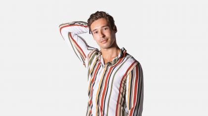 A headshot of a male dancer in a red striped shirt