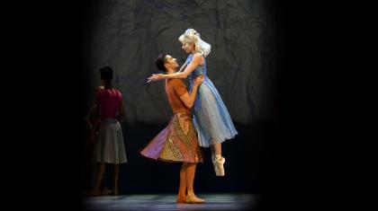 Dancers look into each others eyes lovingly as one gently lifts the other