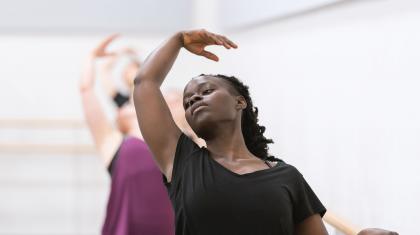 A woman leaning back on a ballet barre