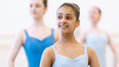 A young girl stood in ballet class