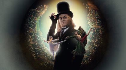 Poster image of A Christmas Carol with Scrooge in his top hat looking mean and in front of him the ghosts of Christmas past and present.
