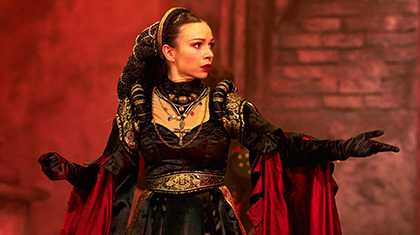 Dressed in black and gold, the imperious Lady Capulet looks displeased
