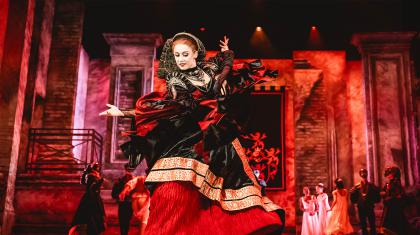 Imperious woman, wearing a red skirt covered with a black dress with heavy gold trimming