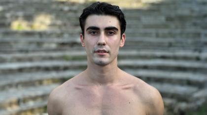 Male dancer, shirtless, dark hair, looking directly at the camera