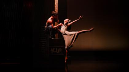 In the glow of a streetlight, two dancers dressed plainly show their love through dance