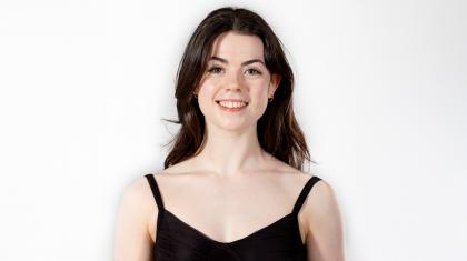 Dancer Eliza Hickey with long, dark hair, open-mouthed smile and a black top