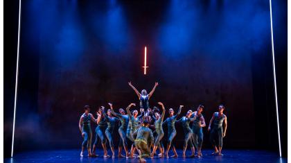 The Ladt of the Lake held aloft by dancers representing the waters raises her arms to the glowing sword just above her head