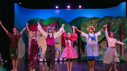 Six dancers in costume of Little Red Riding Hood taking a bow