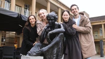 Four Northern Ballet dancers pose with a statue of Anne Lister.