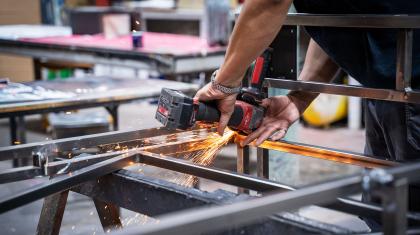 Detailed photo of work on a metal structure with sparks flying from a grinding tool