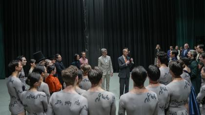 Northern Ballet dancers in a circle on stage meeting HRH The Duke of Edinburgh