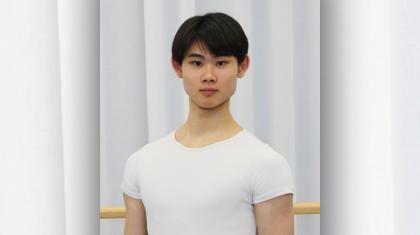 Male dancer with short dark hair wearing a tight white top.